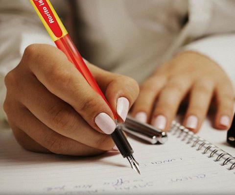 A student writing in a notebook with focus and confidence